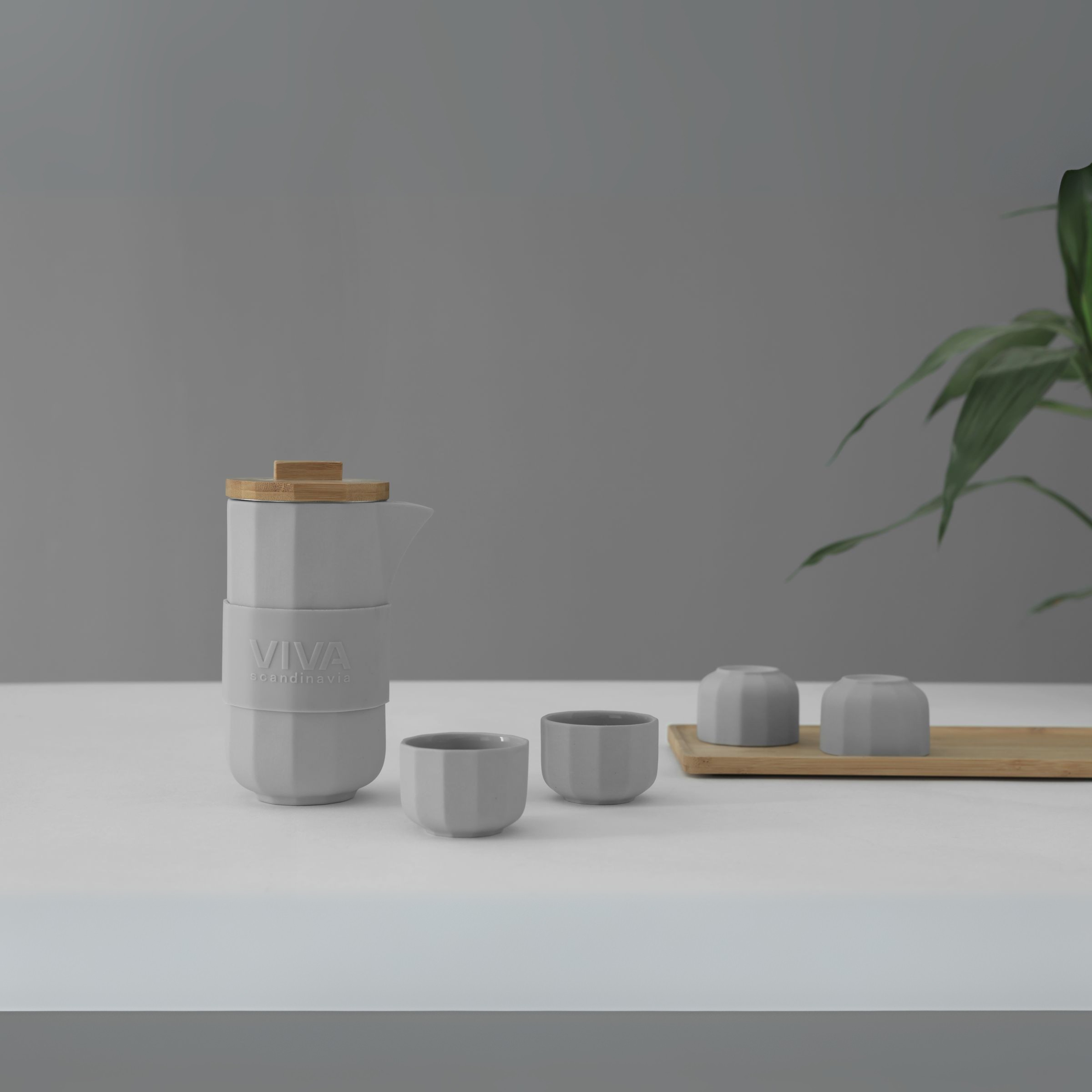 Minimalistische presentatie van de grijze Alexander theeset van Viva Scandinavia, inclusief kopjes en bamboe deksel.