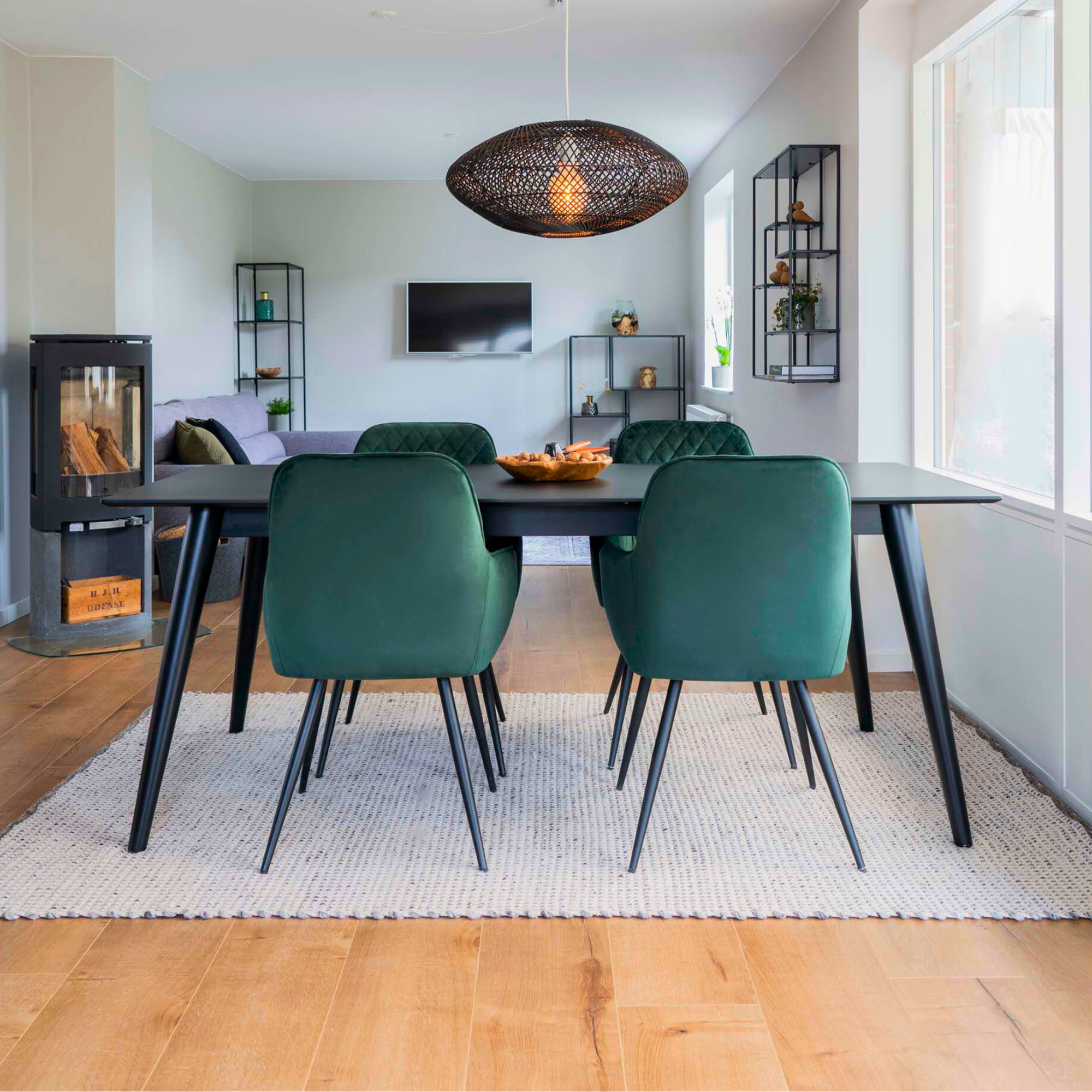 Achterzijde van Harbo eetkamerstoelen in donkergroen velvet rond een zwarte eettafel – moderne en stijlvolle eetkamerinrichting van House Nordic.