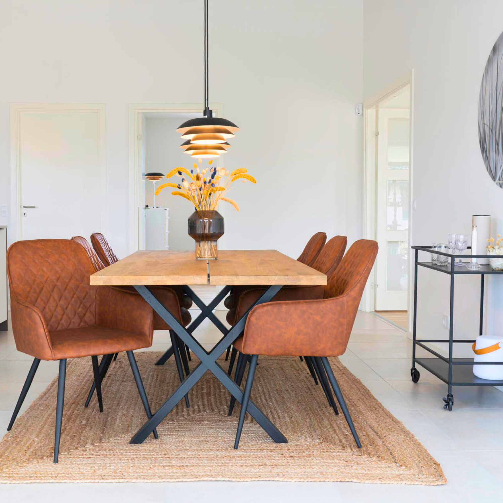 Harbo eetkamerstoelen in vintage bruin PU-leer met zwarte metalen poten, geplaatst aan een houten eettafel in Scandinavisch interieur – House Nordic.