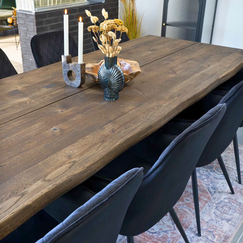 Achterzijde van Harbo eetkamerstoelen in zwart velvet rond een houten eettafel – moderne en stijlvolle eetkamerinrichting van House Nordic.