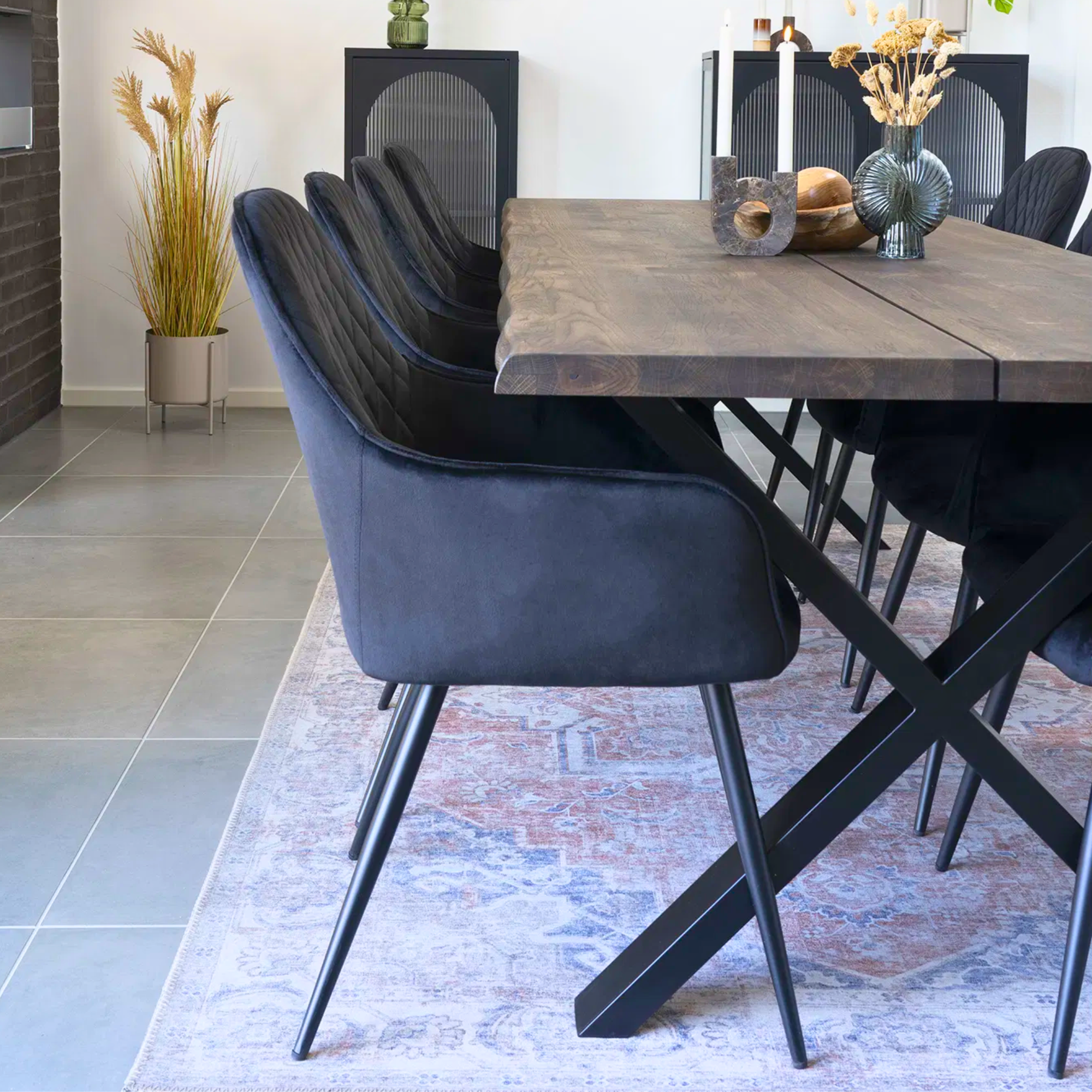 Set van Harbo eetkamerstoelen in zwart velvet rond een houten eettafel – Scandinavisch geïnspireerde eetkamer met moderne accenten van House Nordic.