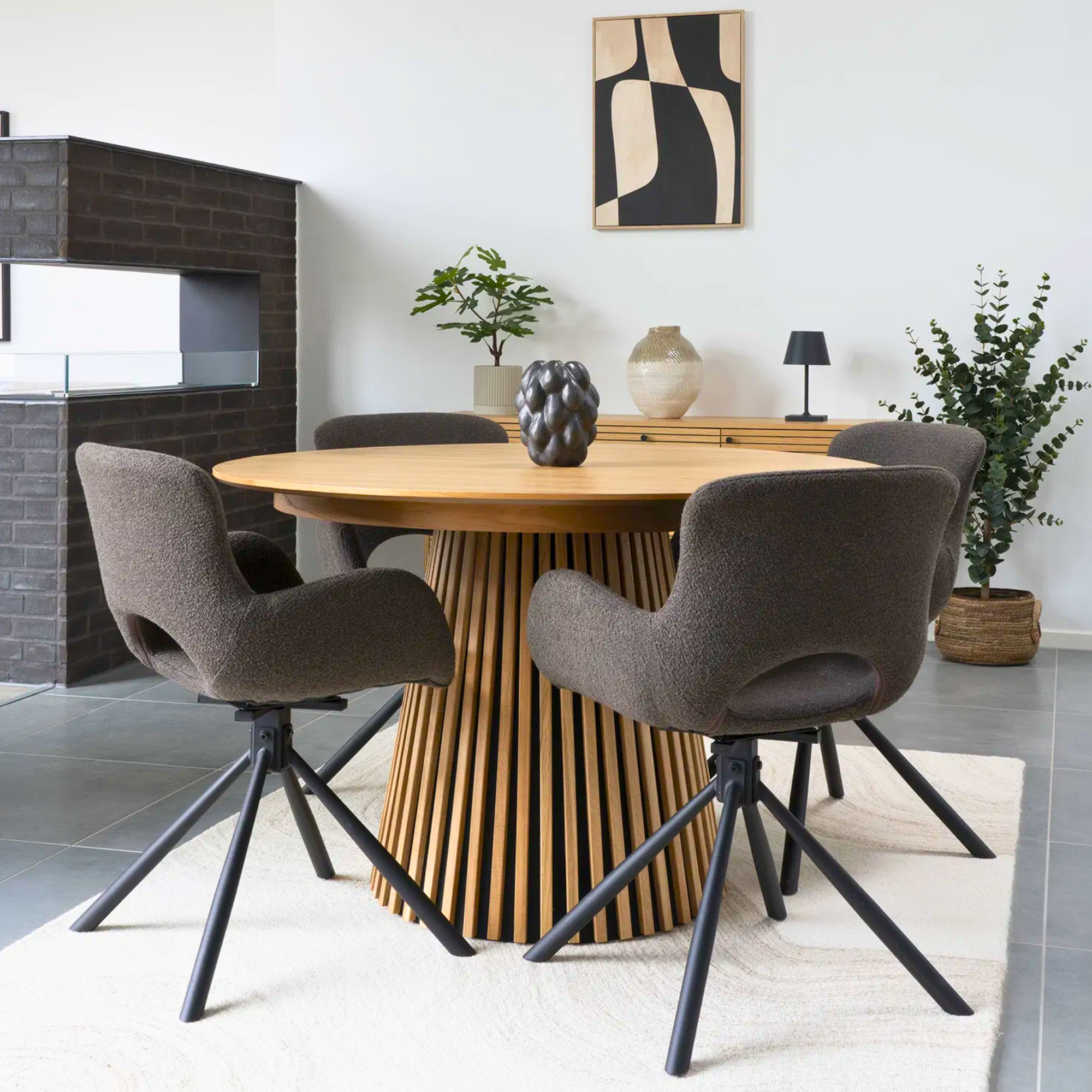 Set van Amorim eetkamerstoelen in bouclé stof in de kleur mushroom met zwarte metalen draaivoet, geplaatst rond een houten eettafel in een Scandinavisch interieur van House Nordic.