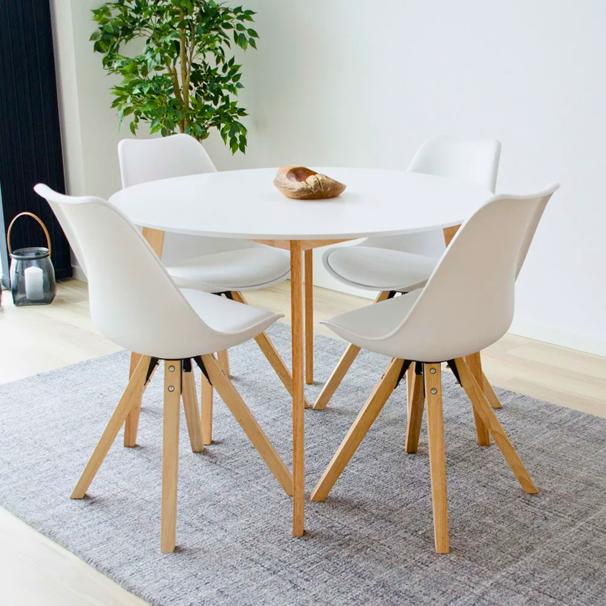 Set witte House Nordic Bergen eetkamerstoelen met houten poten rond witte tafel in Scandinavisch interieur.