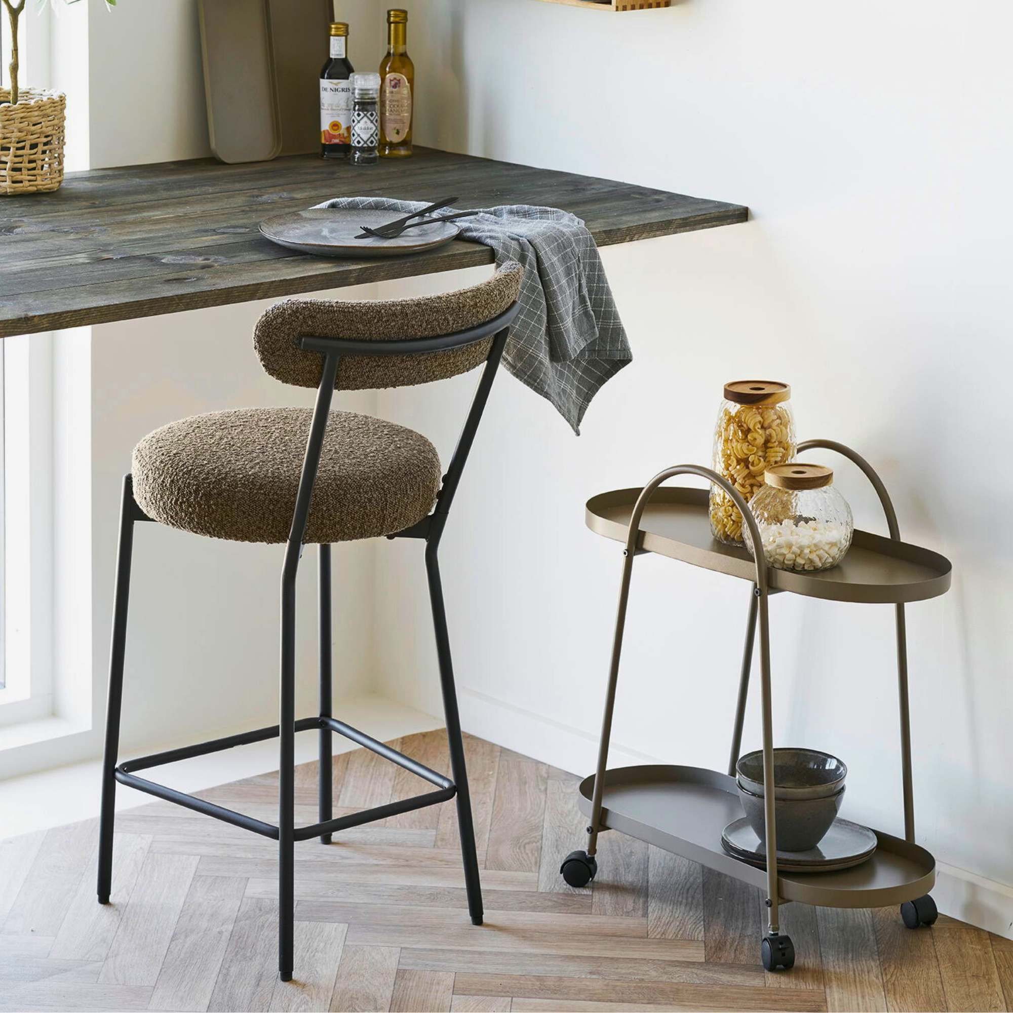 House Nordic Empoli serveerwagen in bruin staal – elegante drankentrolley naast een keukeneiland in een Scandinavisch interieur.