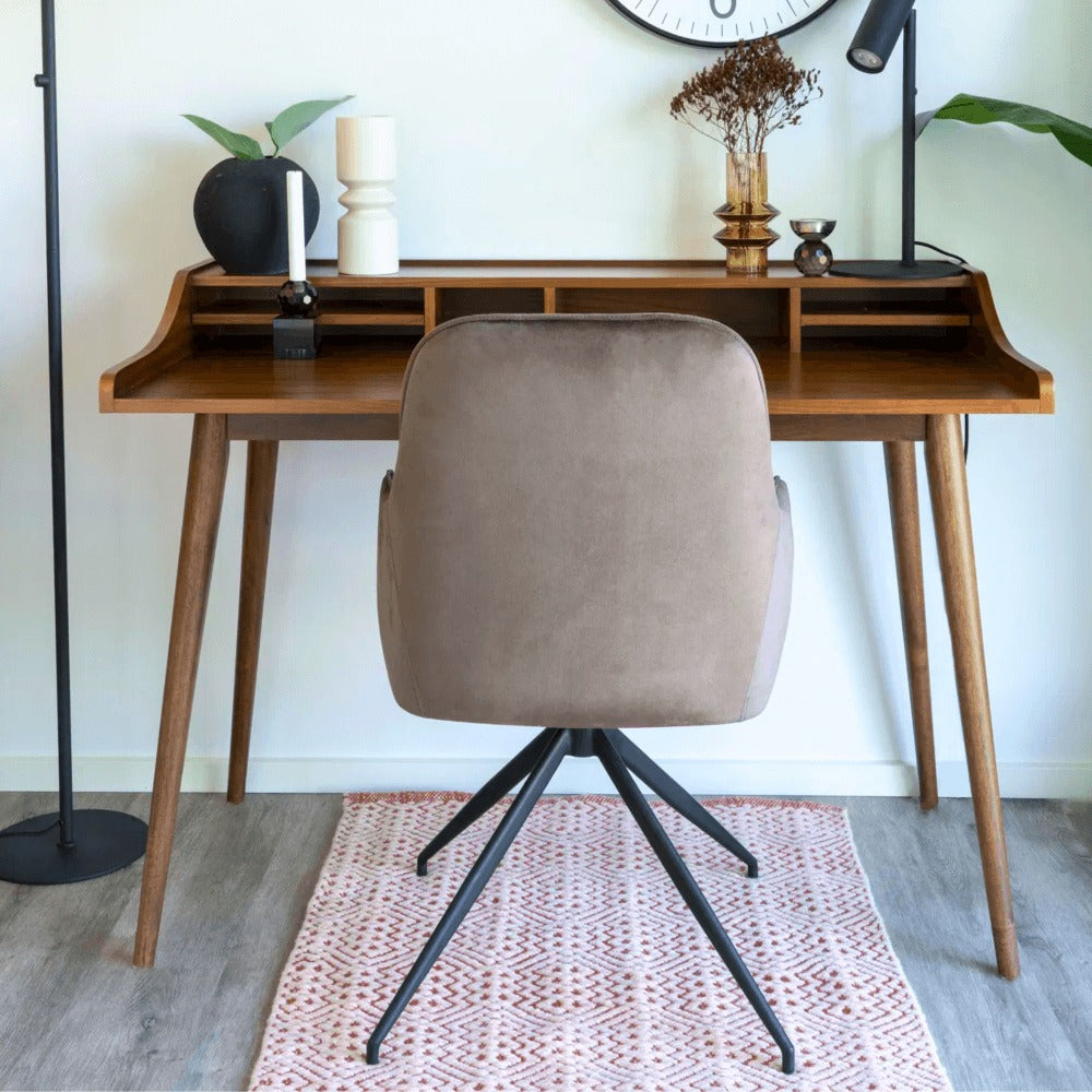 Achteraanzicht van de House Nordic Harbo eetkamerstoel in lichtbruin velvet met zwarte metalen poten, geplaatst aan een houten bureau in Scandinavische stijl.