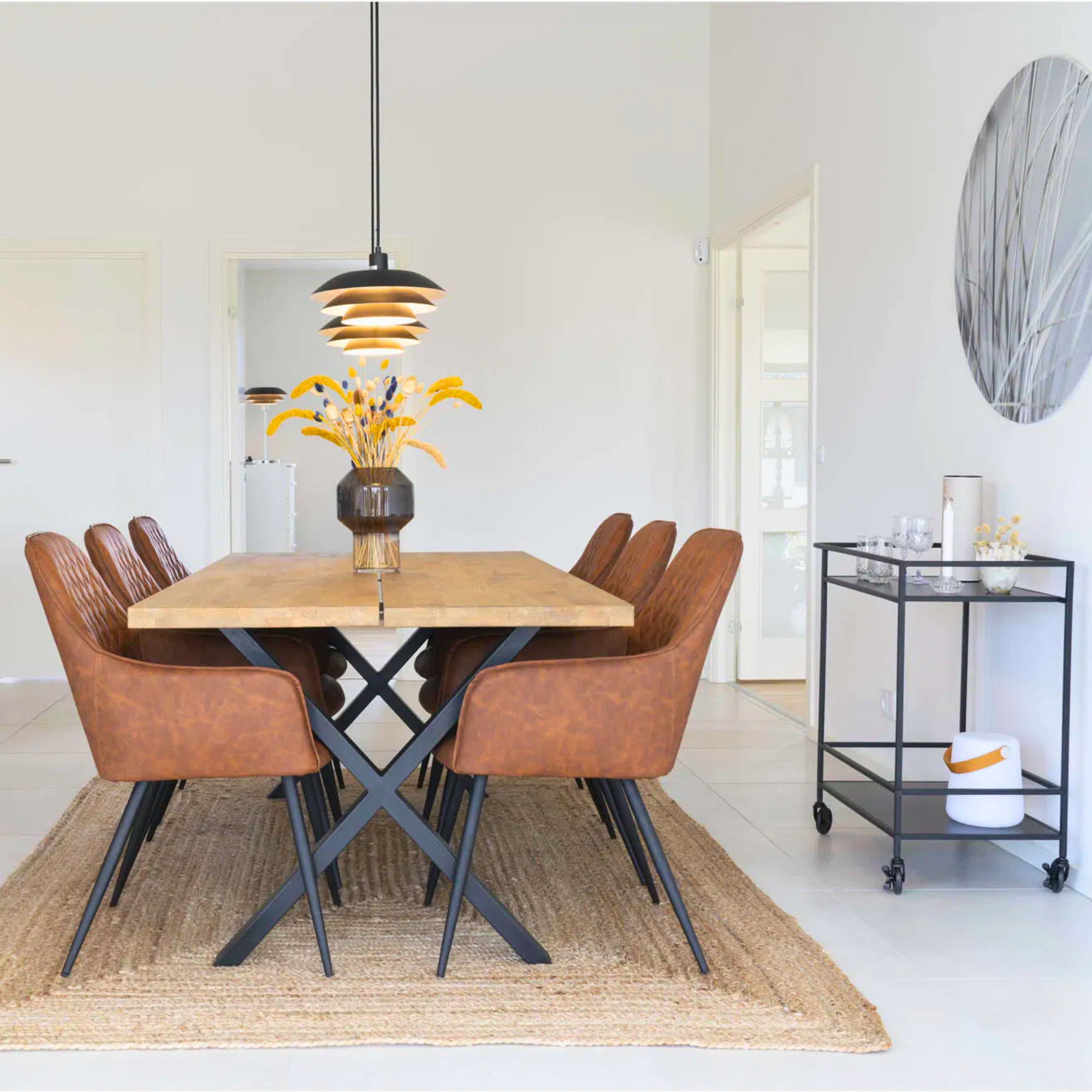 Set van bruine House Nordic Harbo eetkamerstoelen rond houten eettafel – moderne eetkamer met PU-leren stoelen en zwarte metalen poten.