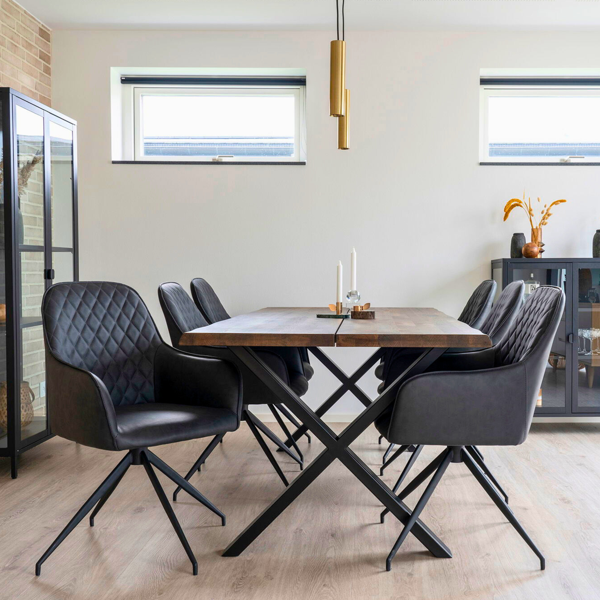 Donkergrijze House Nordic Harbo eetkamerstoelen rond een houten eettafel in een modern Scandinavisch interieur met lichte muren en gouden accenten.