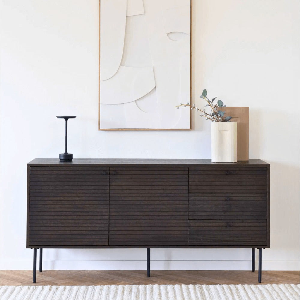 House Nordic Lyneham LED tafellamp in zwart op een modern donkerhouten dressoir in een stijlvol interieur met wandkunst en decoratie.