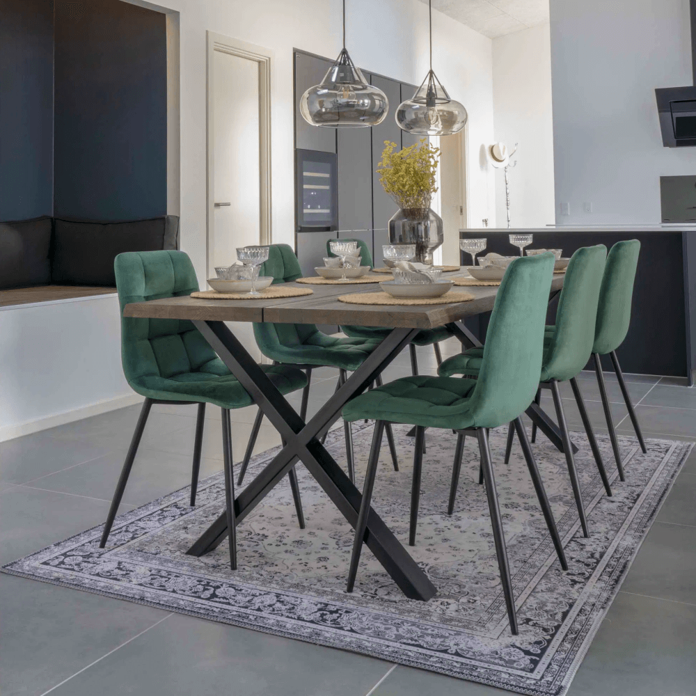 Moderne eetkamer met House Nordic Middelfart eetkamerstoelen in donkergroen velvet met zwarte poten rond eettafel met industriële look.