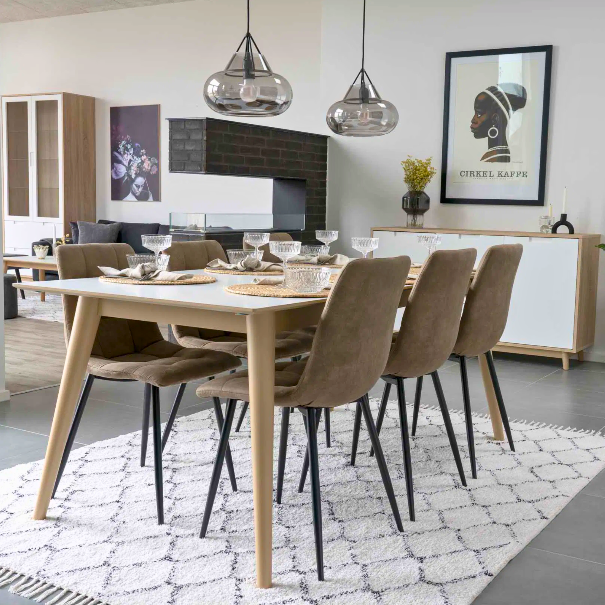 House Nordic Middelfart eetkamerstoelen in lichtbruin microvezel met zwarte metalen poten rond een houten eettafel in Scandinavisch interieur.