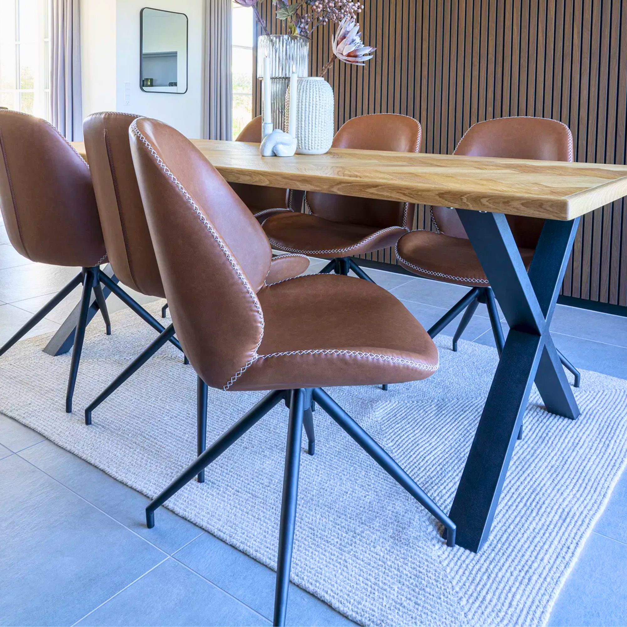 Monte Carlo eetkamerstoelen van House Nordic in bruin PU-leer rond een houten eettafel met zwarte metalen poten in modern interieur.