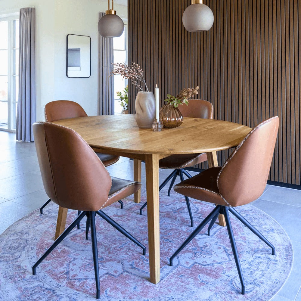 Interieurfoto met Monte Carlo eetkamerstoelen van House Nordic in bruin PU-leer rond een houten eettafel met zwarte metalen poten.