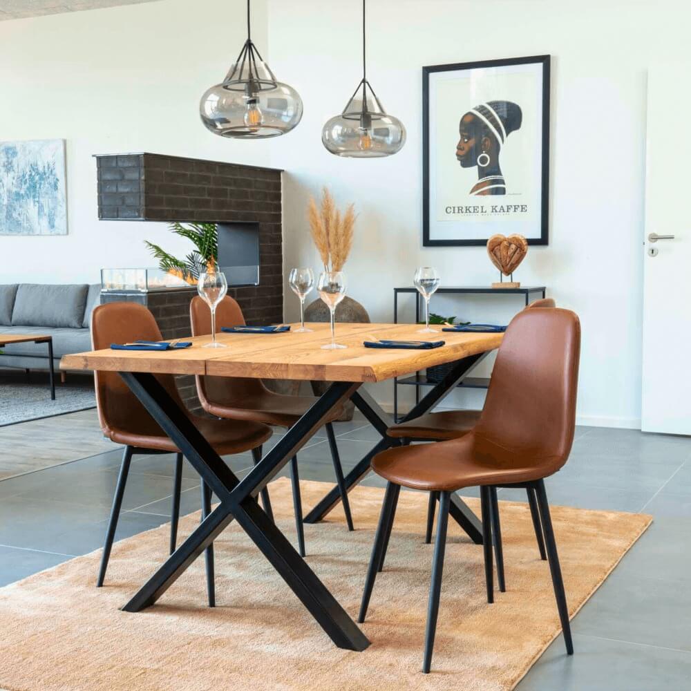 Scandinavisch interieur met House Nordic Stockholm eetkamerstoelen in bruin PU-leer met zwarte metalen poten rond een houten eettafel.