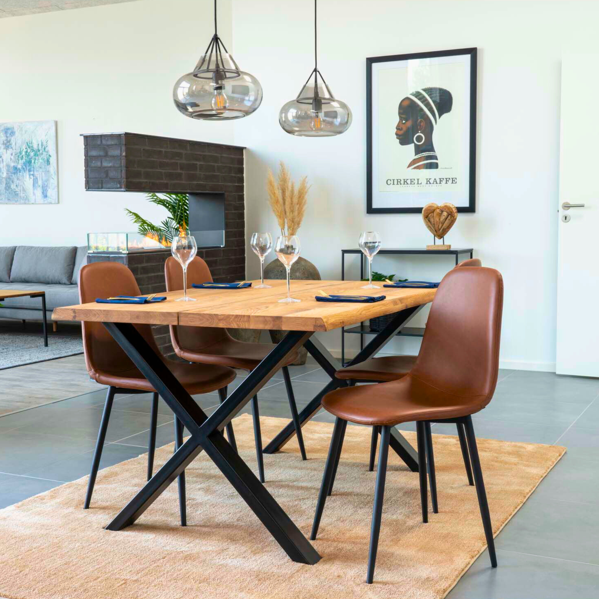 Scandinavisch interieur met House Nordic Stockholm eetkamerstoelen in bruin PU-leer met zwarte metalen poten rond een houten eettafel.