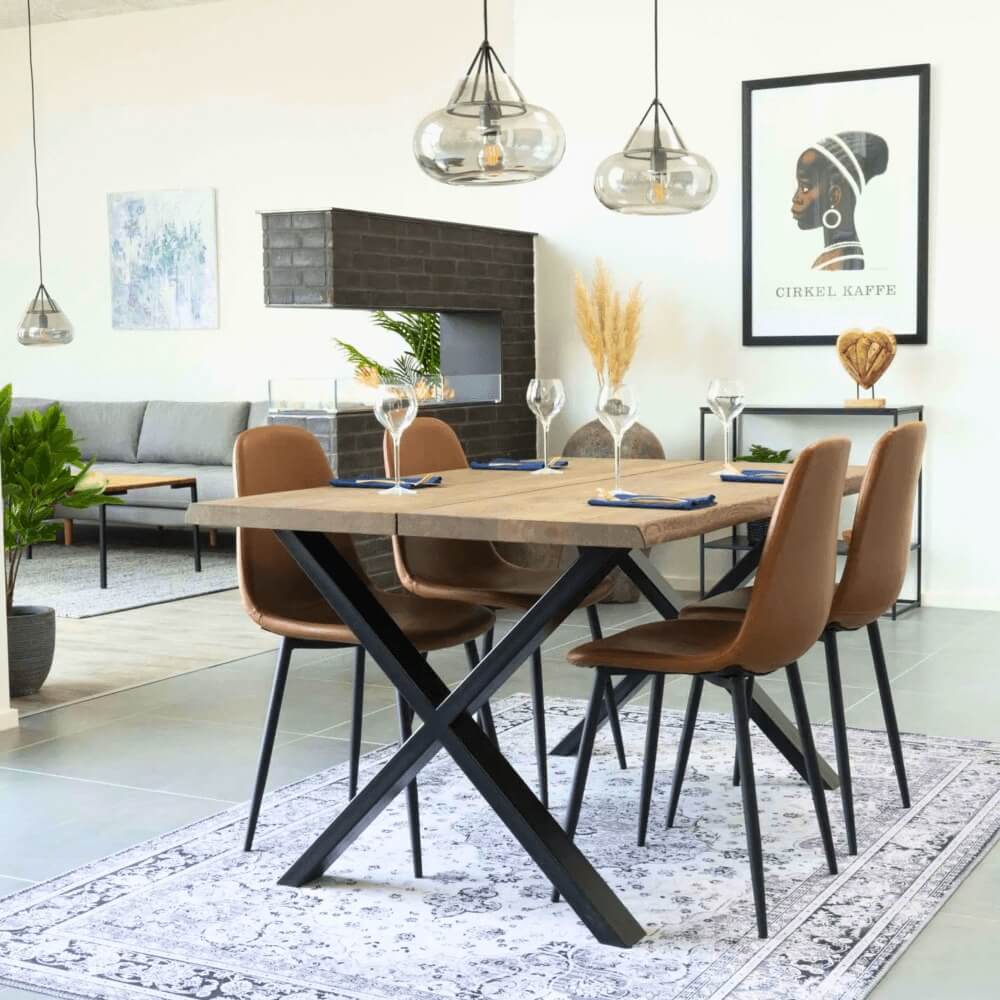 Eetkamer met House Nordic Stockholm stoelen in bruin PU-leer en zwarte poten, gecombineerd met houten tafel in Scandinavisch interieur.