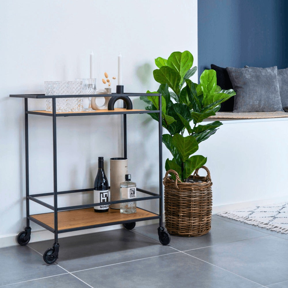 House Nordic Vita serveerwagen in bruin hout met zwart metalen frame – stijlvolle drankentrolley in Scandinavisch interieur met planten en decoratie.