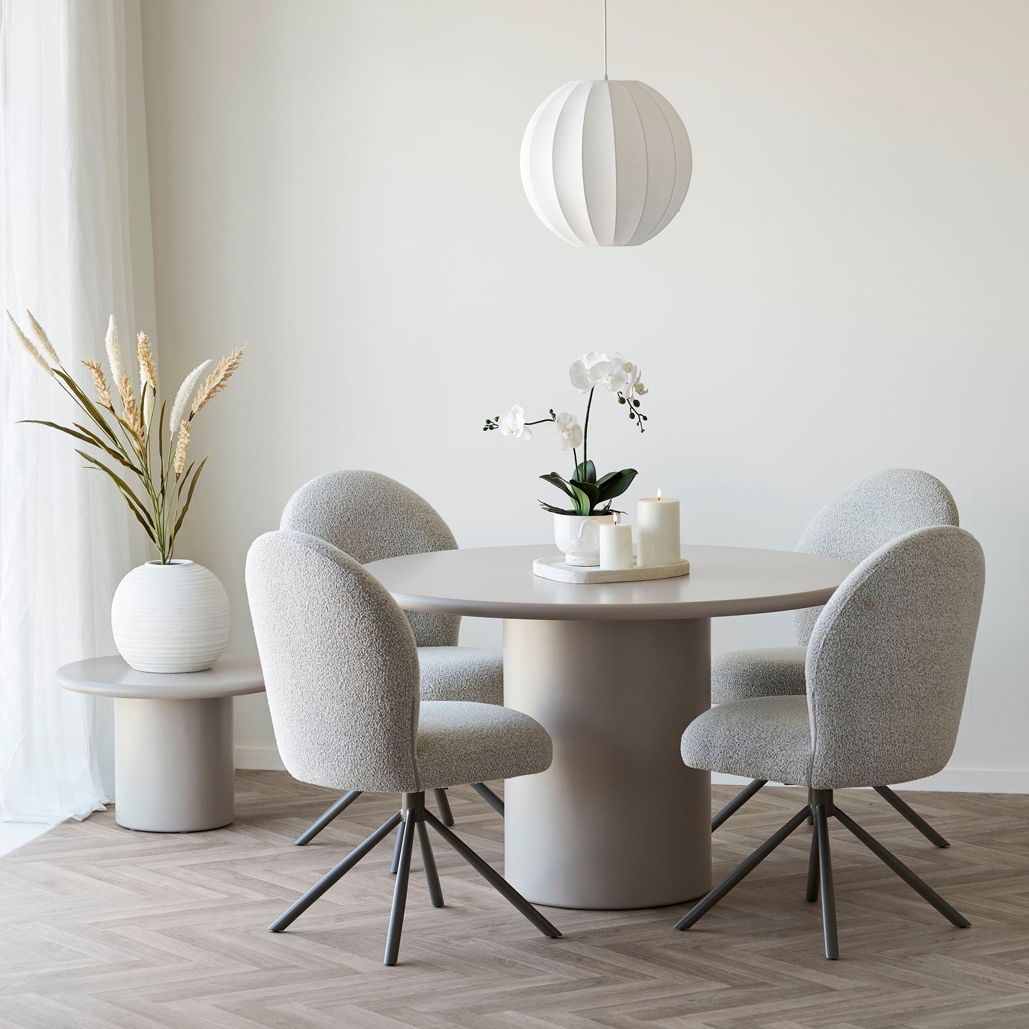 Set van vier Lana eetkamerstoelen in zandkleurige bouclé stof rond een beige eettafel – moderne Scandinavische eetkamerinrichting van House Nordic.