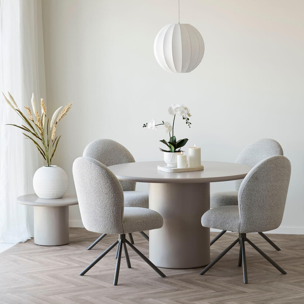Set van vier Lana eetkamerstoelen in zandkleurige bouclé stof rond een beige eettafel – moderne Scandinavische eetkamerinrichting van House Nordic.