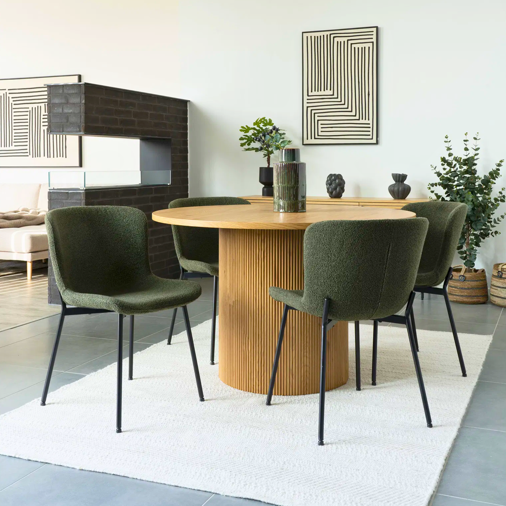 Maceda eetkamerstoelen in donkergroene bouclé met zwarte metalen poten van House Nordic, rond eettafel in modern Scandinavisch interieur.