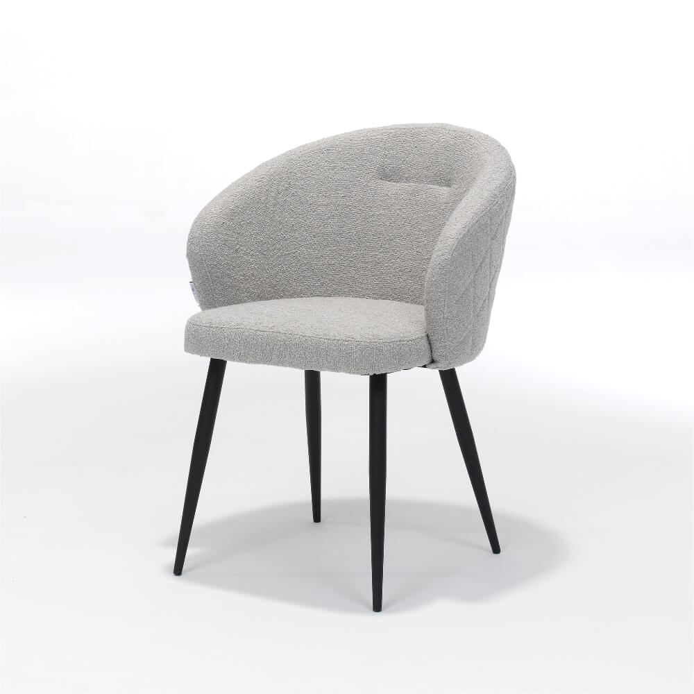 De RV Design Kelly stoel in naturel teddy stof met een zwart metalen onderstel. Vooraanzicht van De luxe eetkamerstoel.