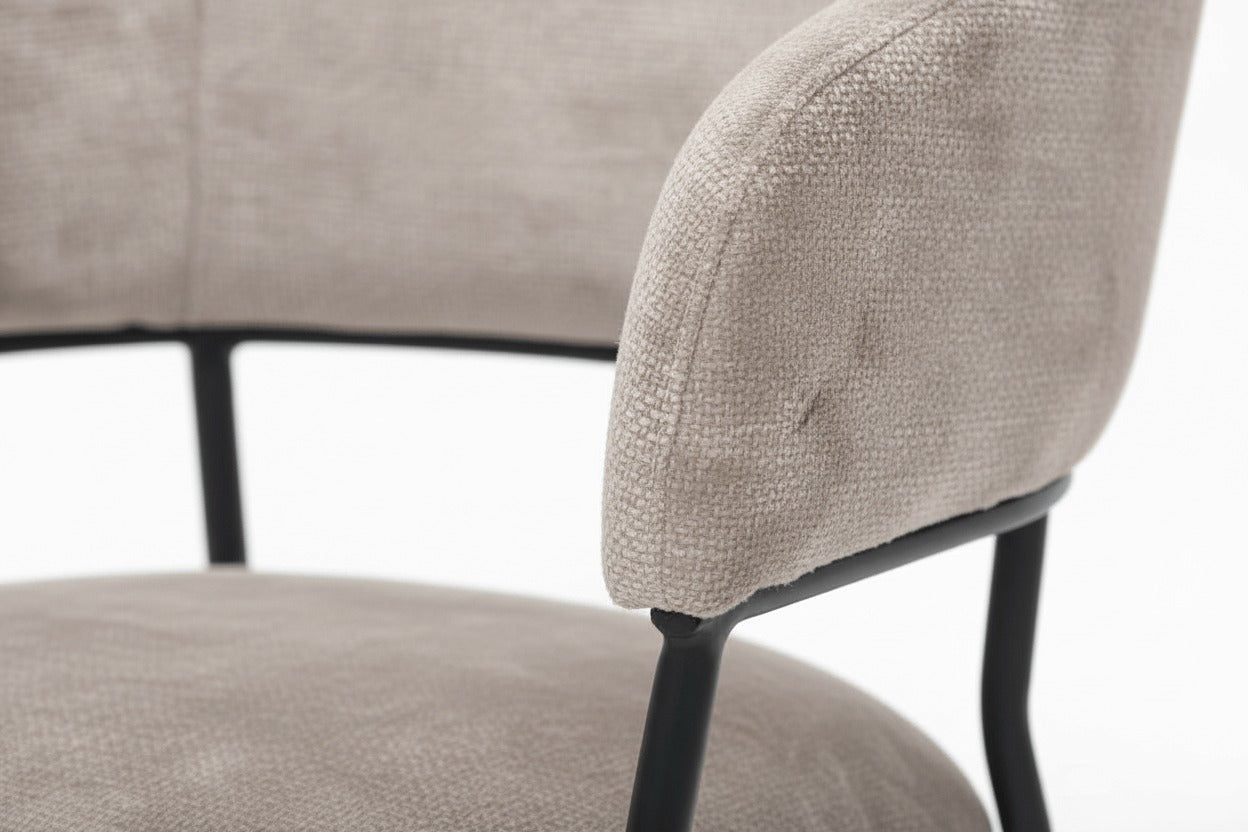 Detail van de RV Design Liam armstoel in naturel stof met zwart metalen onderstel, close-up van rugleuning en zitting.