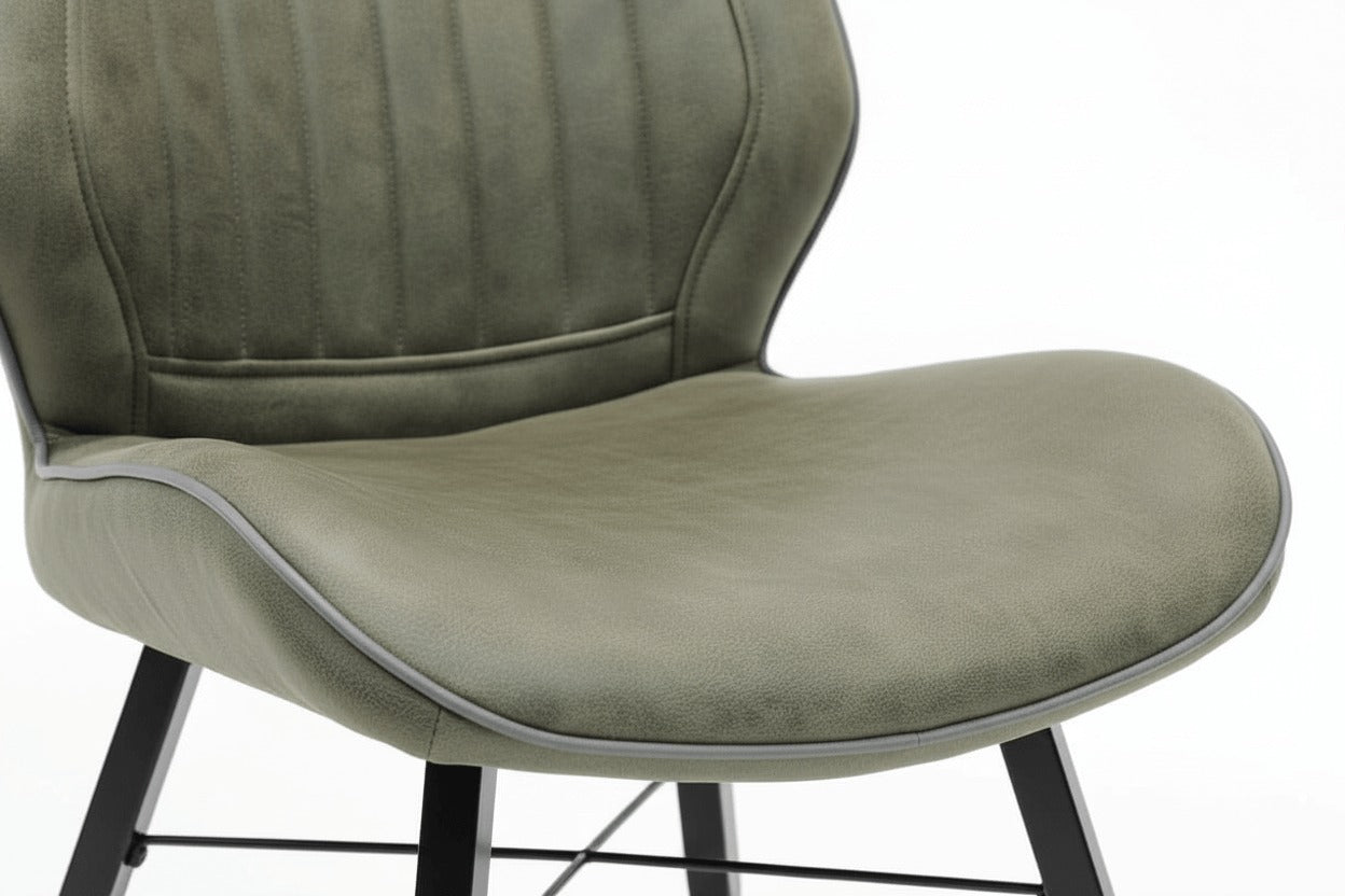 Detail van de zitting van de RV Design Quattro eetkamerstoel in groene soft stof met ergonomische vorm en zwart metalen onderstel.