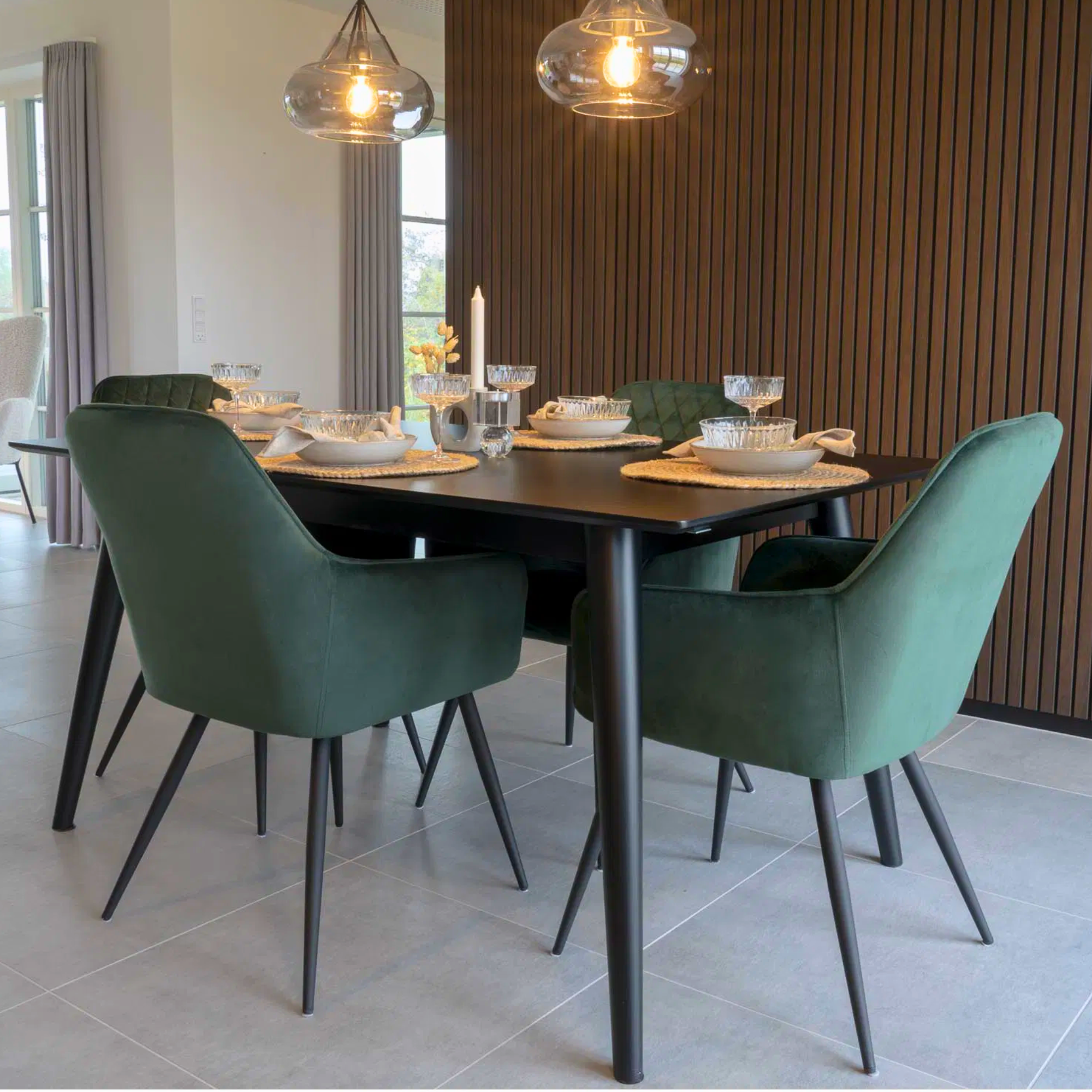 Set van Harbo eetkamerstoelen in groen velvet met zwarte metalen poten rond een moderne eettafel – stijlvolle eetkamerinrichting van House Nordic.