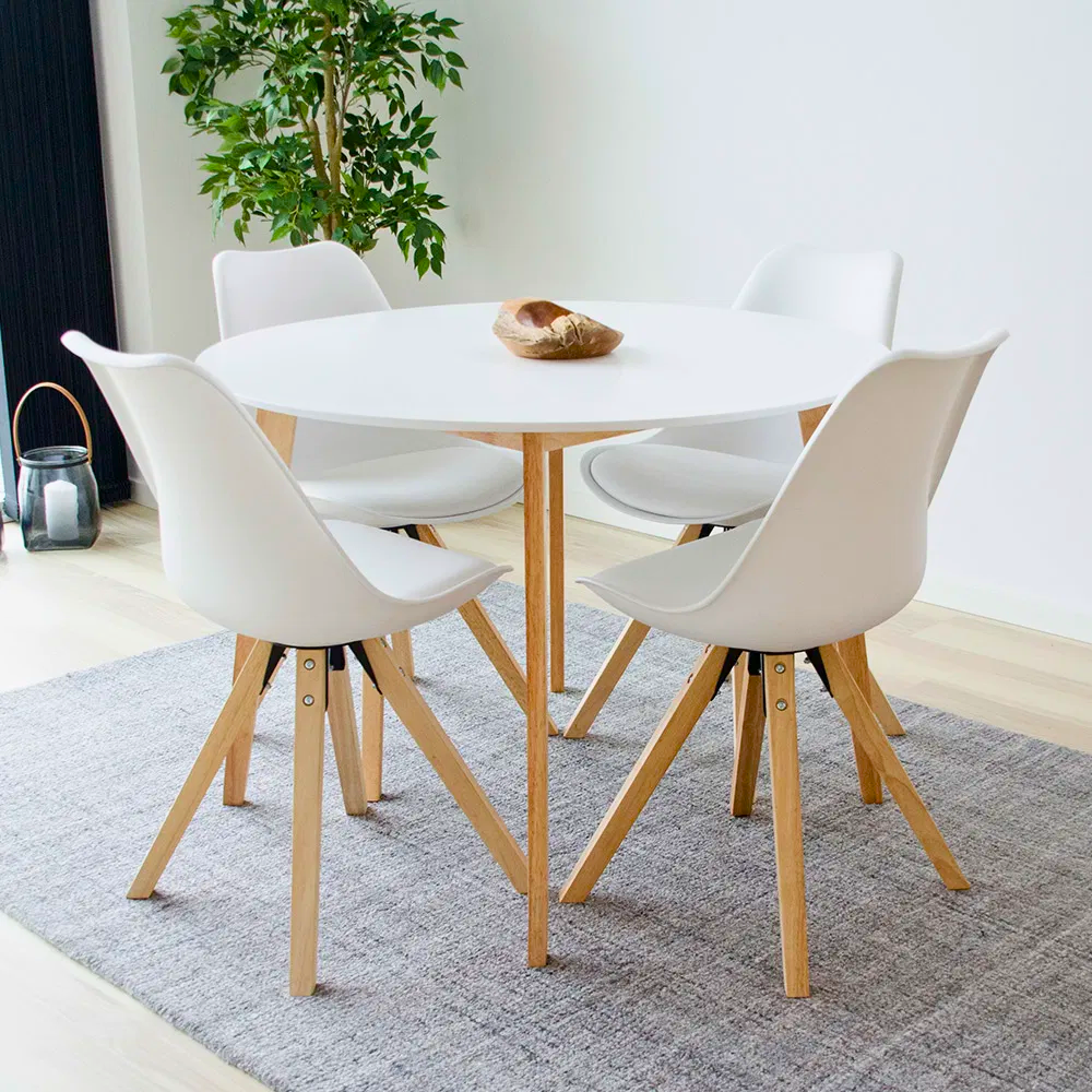 Moderne eetkamer met witte House Nordic Bergen eetkamerstoelen met houten poten rond een ronde witte eettafel.