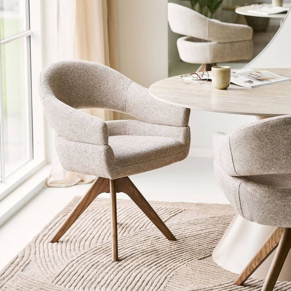 House Nordic Dover eetkamerstoel in zandkleurige stof bij ronde eettafel in Scandinavisch interieur.