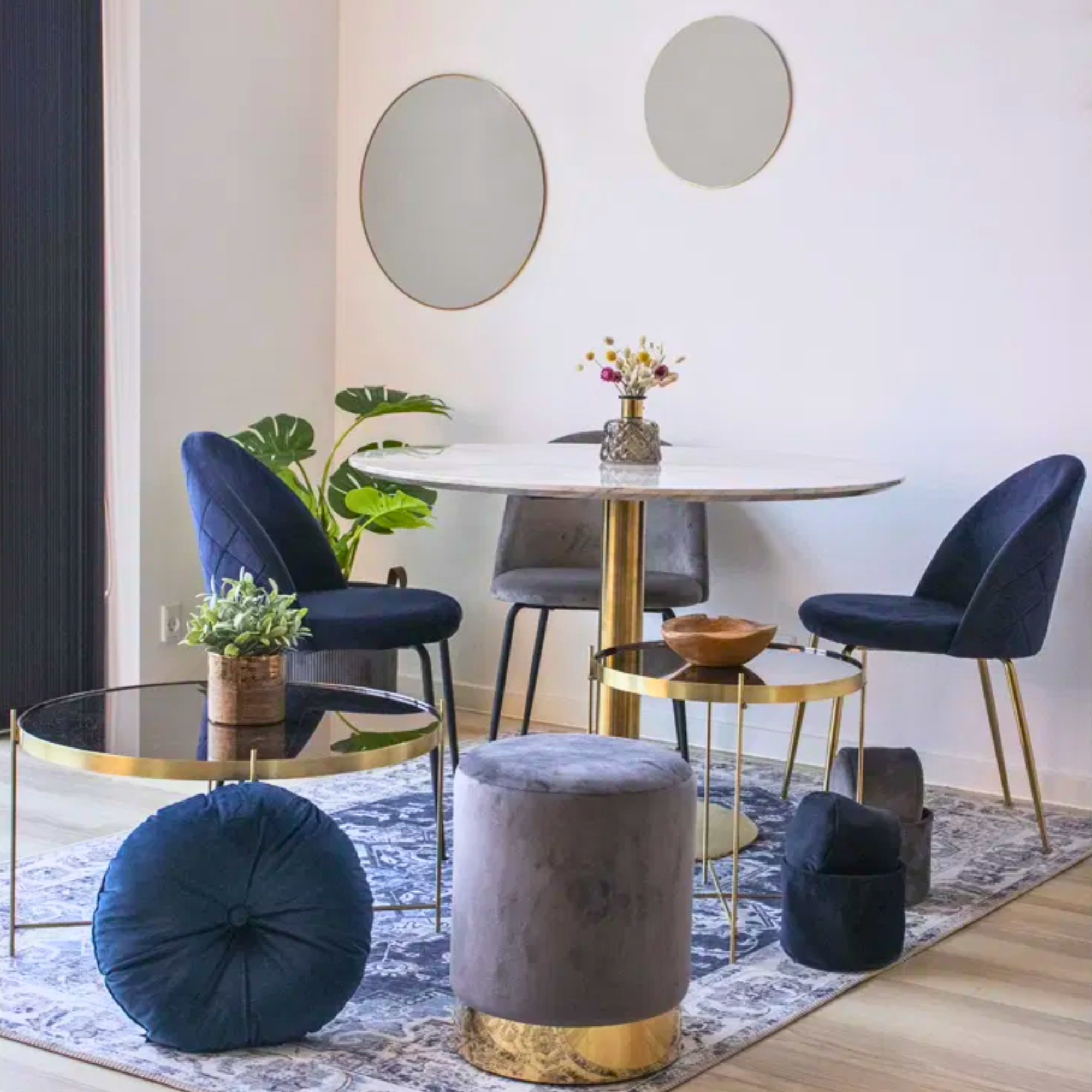 Donkerblauwe velvet eetkamerstoelen met gouden poten van House Nordic, stijlvol geplaatst aan een ronde eettafel in een modern Scandinavisch interieur – verkrijgbaar bij Lunero.