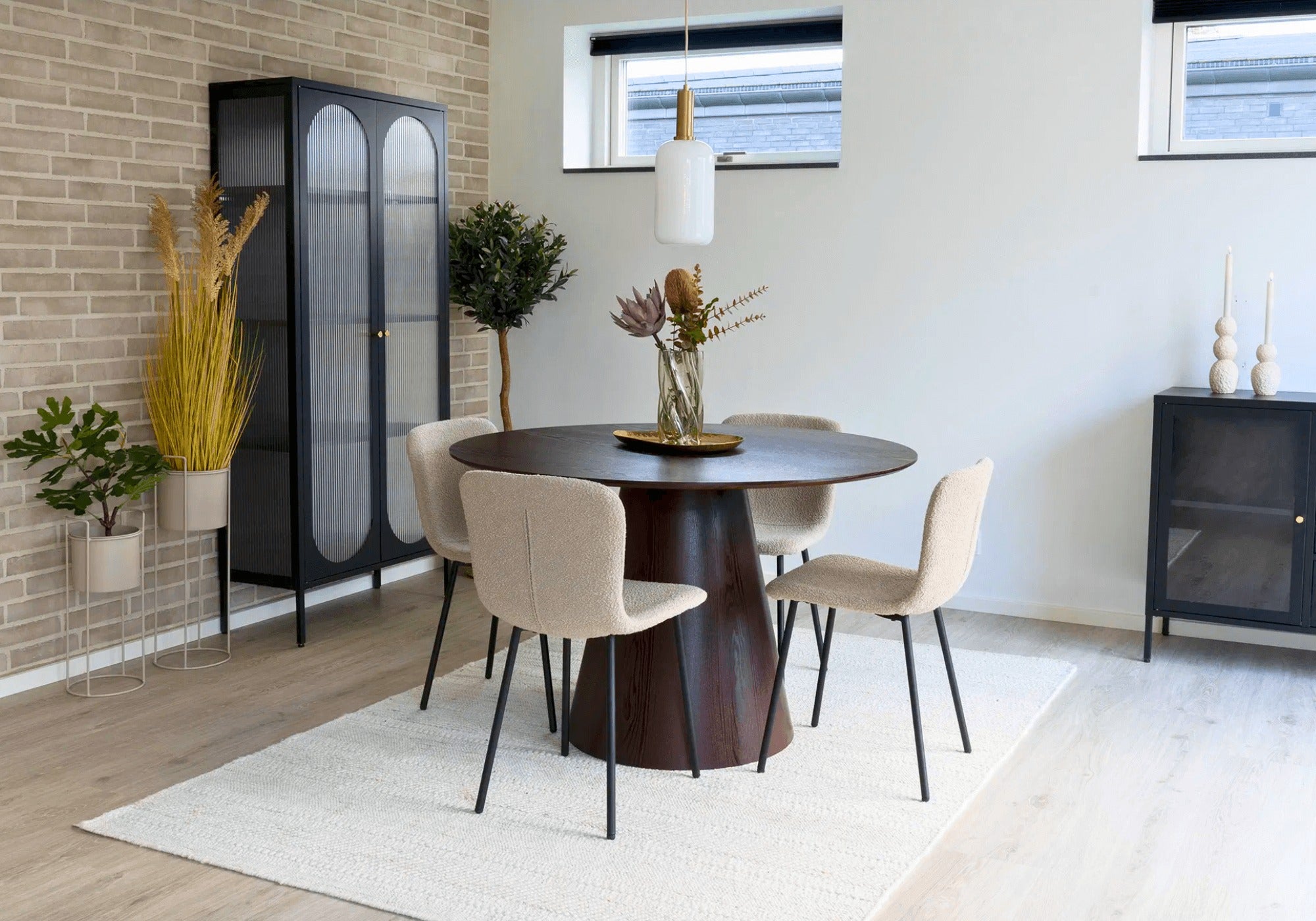 Moderne eetkamer met Halden eetkamerstoelen van House Nordic in beige bouclé met zwarte poten rond een donkere houten tafel, Scandinavisch design.