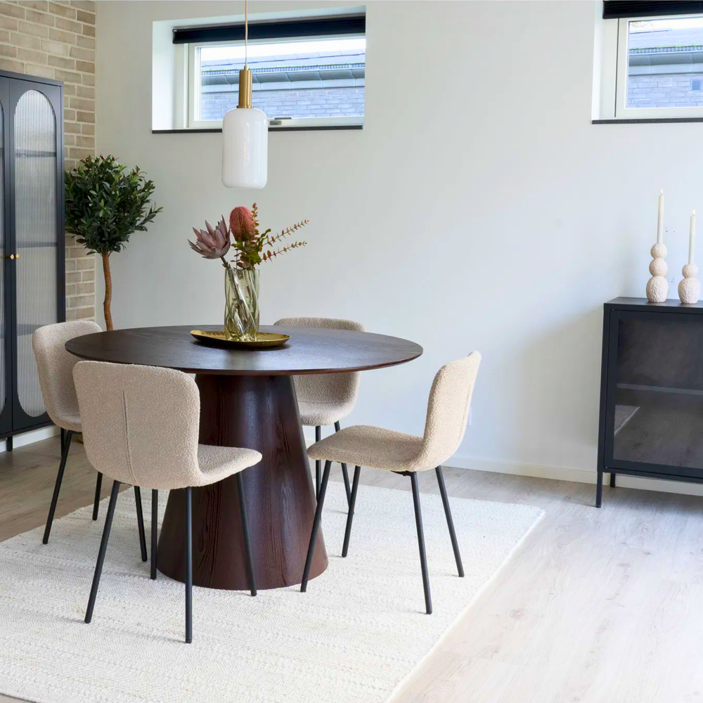 Moderne eetkamer met Halden eetkamerstoelen van House Nordic in beige bouclé met zwarte poten rond een donkere houten tafel, Scandinavisch design.
