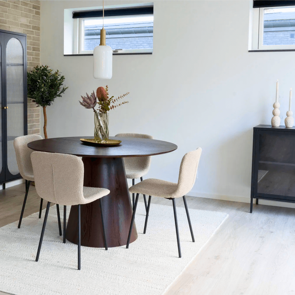 Moderne eetkamer met Halden eetkamerstoelen van House Nordic in beige bouclé met zwarte poten rond een donkere houten tafel, Scandinavisch design.