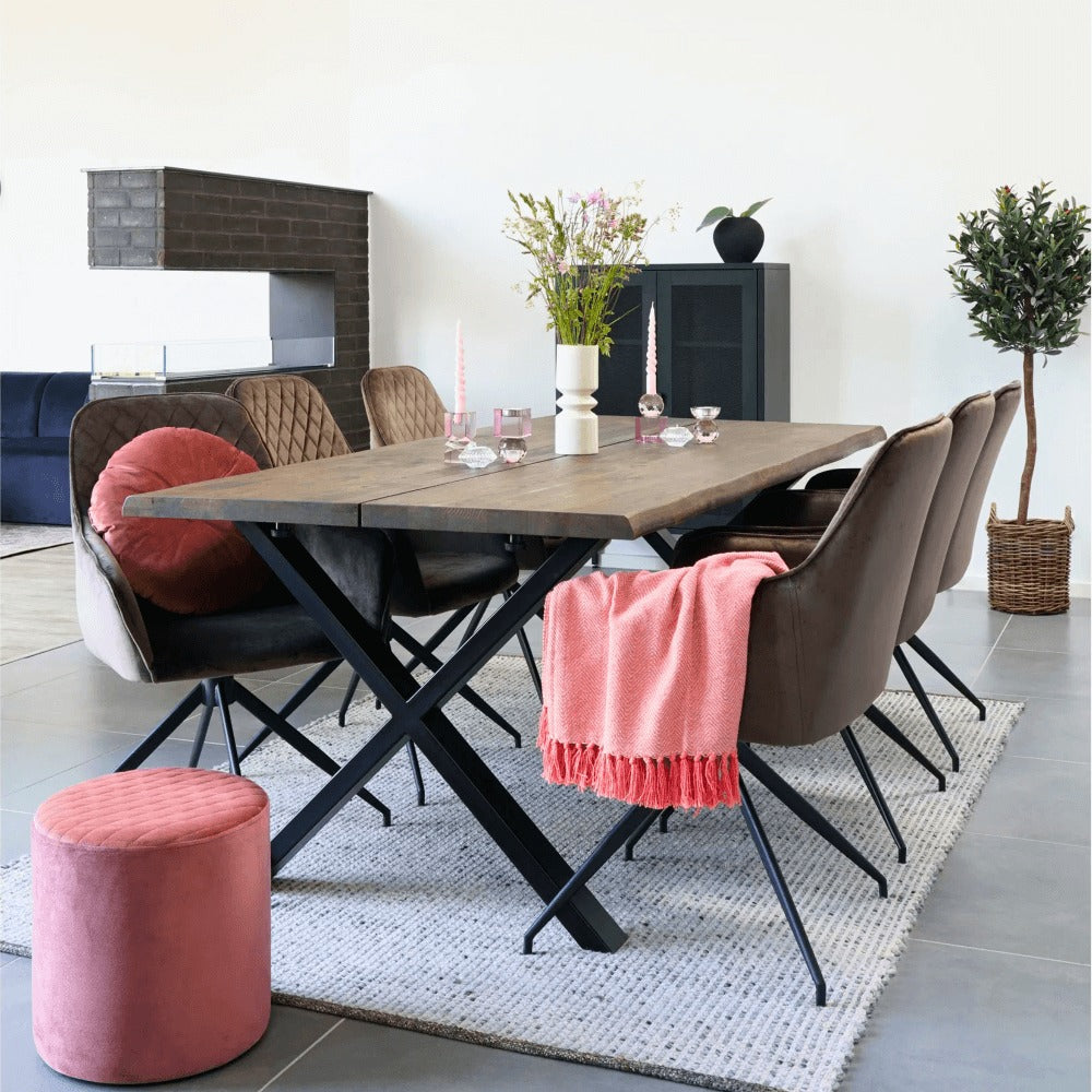Scandinavische eetkamer met House Nordic Harbo eetkamerstoelen in lichtbruin velvet rond een houten tafel, gestyled met roze accenten en planten.