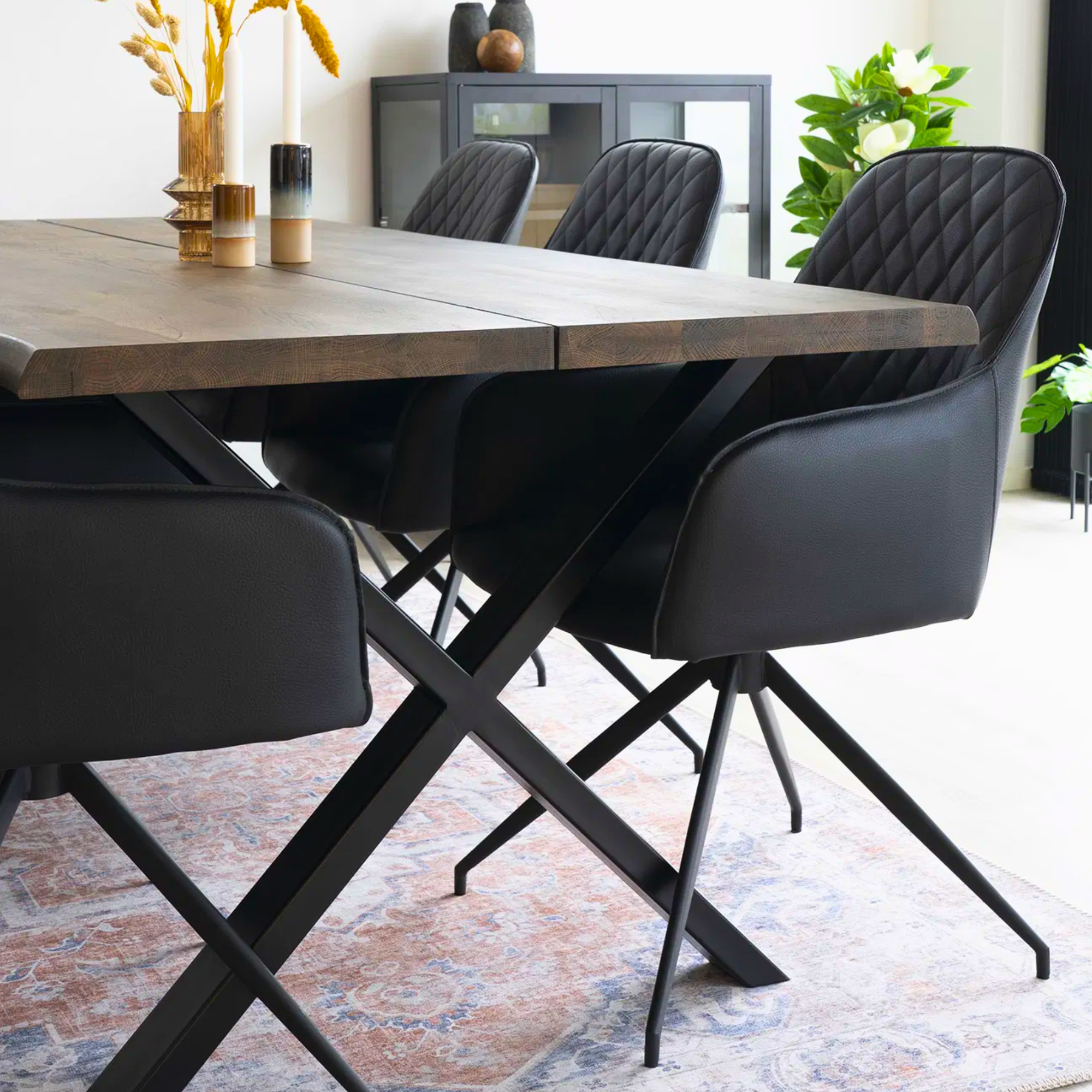 Close-up van zwarte House Nordic Harbo eetkamerstoelen in PU-leer rond een houten eettafel met Scandinavisch design.