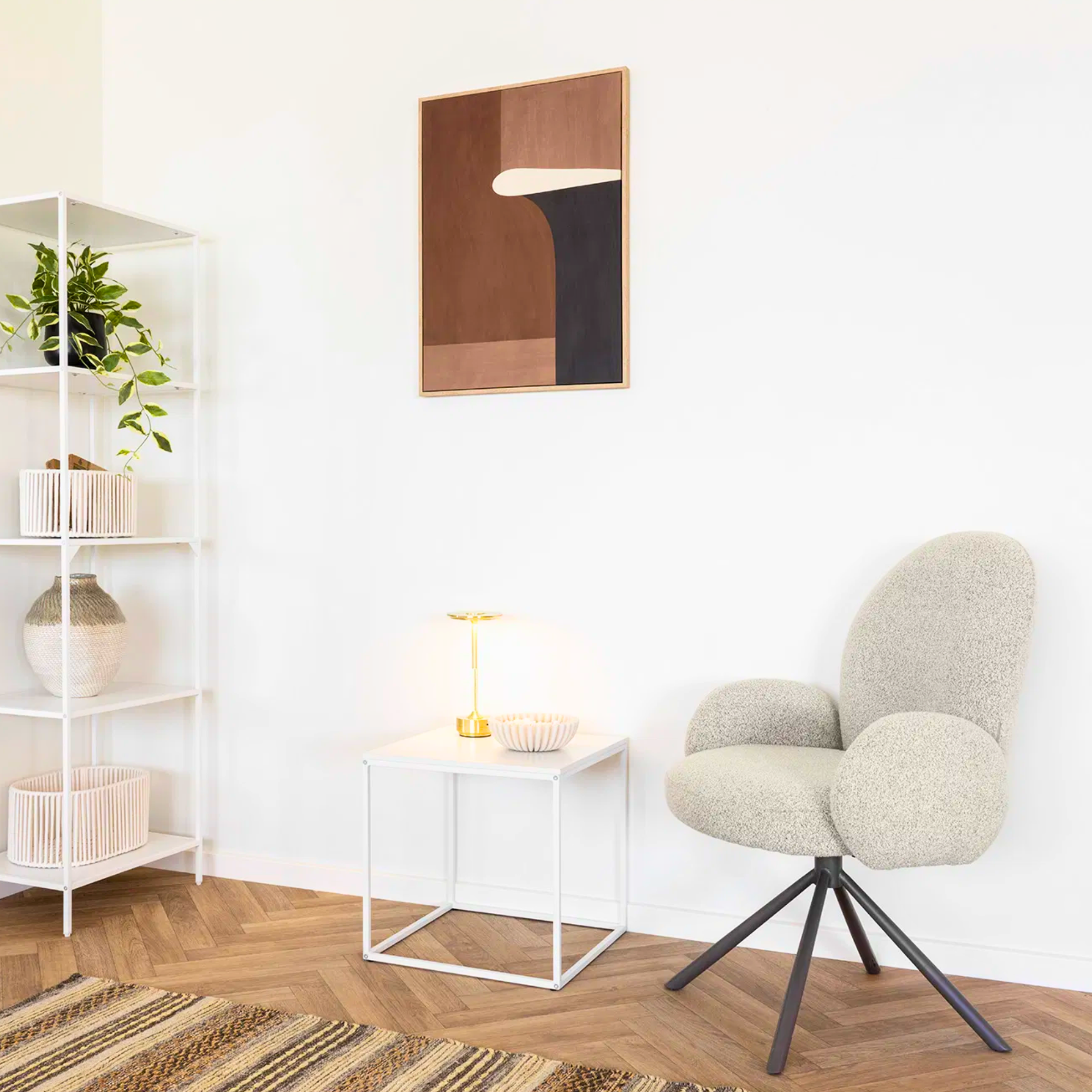 House Nordic Lana eetkamerstoel met armleuningen in zandkleurige bouclé stof, geplaatst in een Scandinavische woonkamerhoek met modern decor.