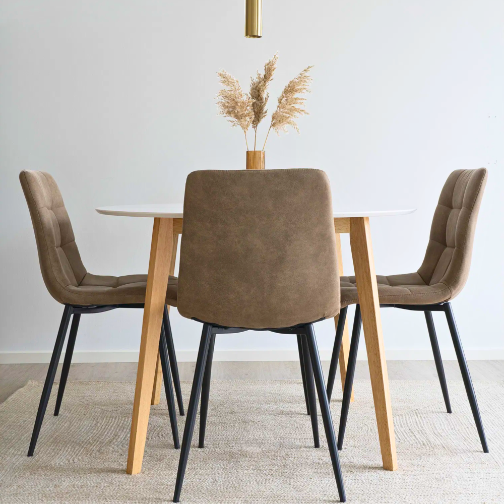 House Nordic Middelfart eetkamerstoelen in lichtbruin microvezel met zwarte poten rond houten eettafel in licht Scandinavisch interieur.