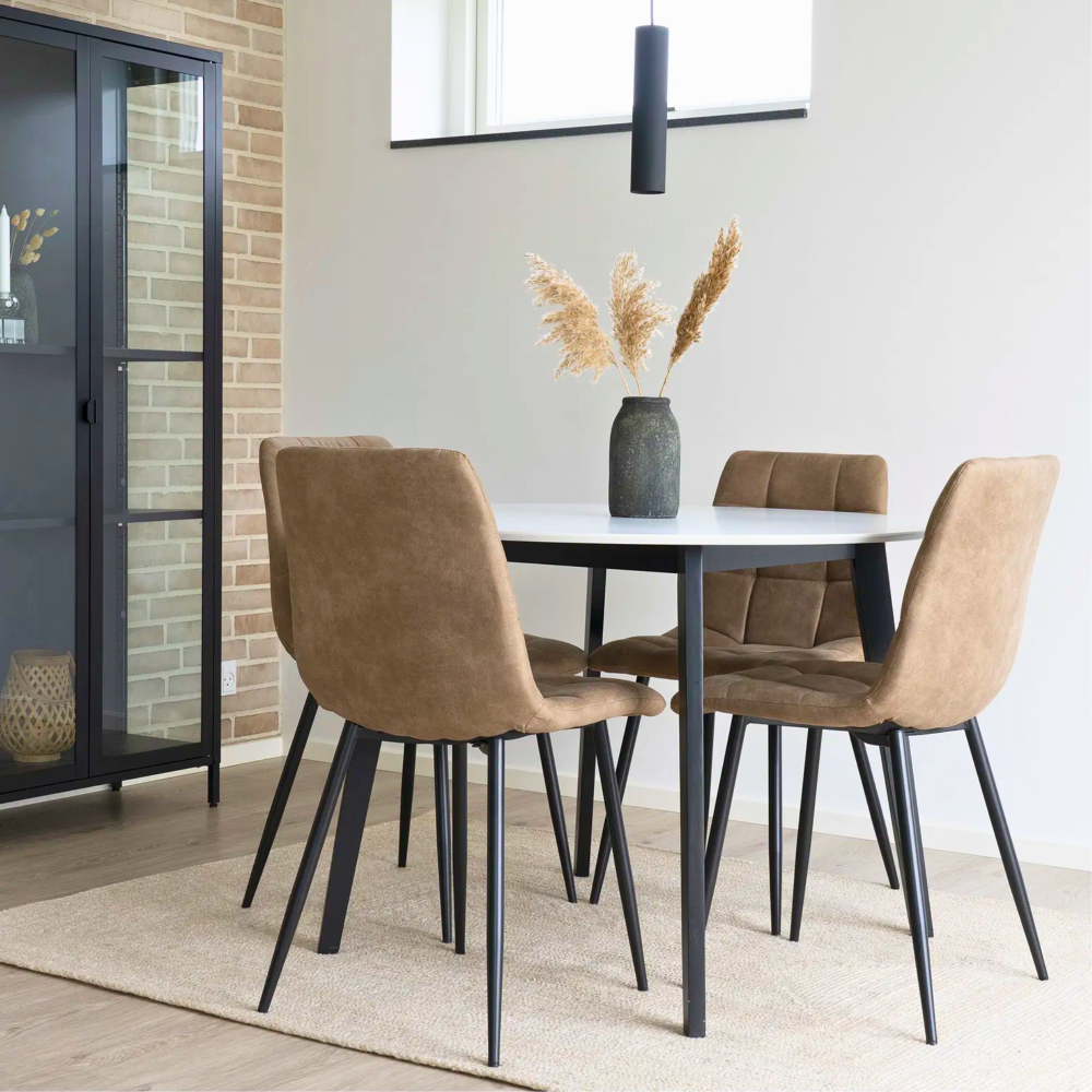 House Nordic Middelfart eetkamerstoelen in lichtbruin microvezel met zwarte metalen poten rond witte eettafel in Scandinavisch interieur.
