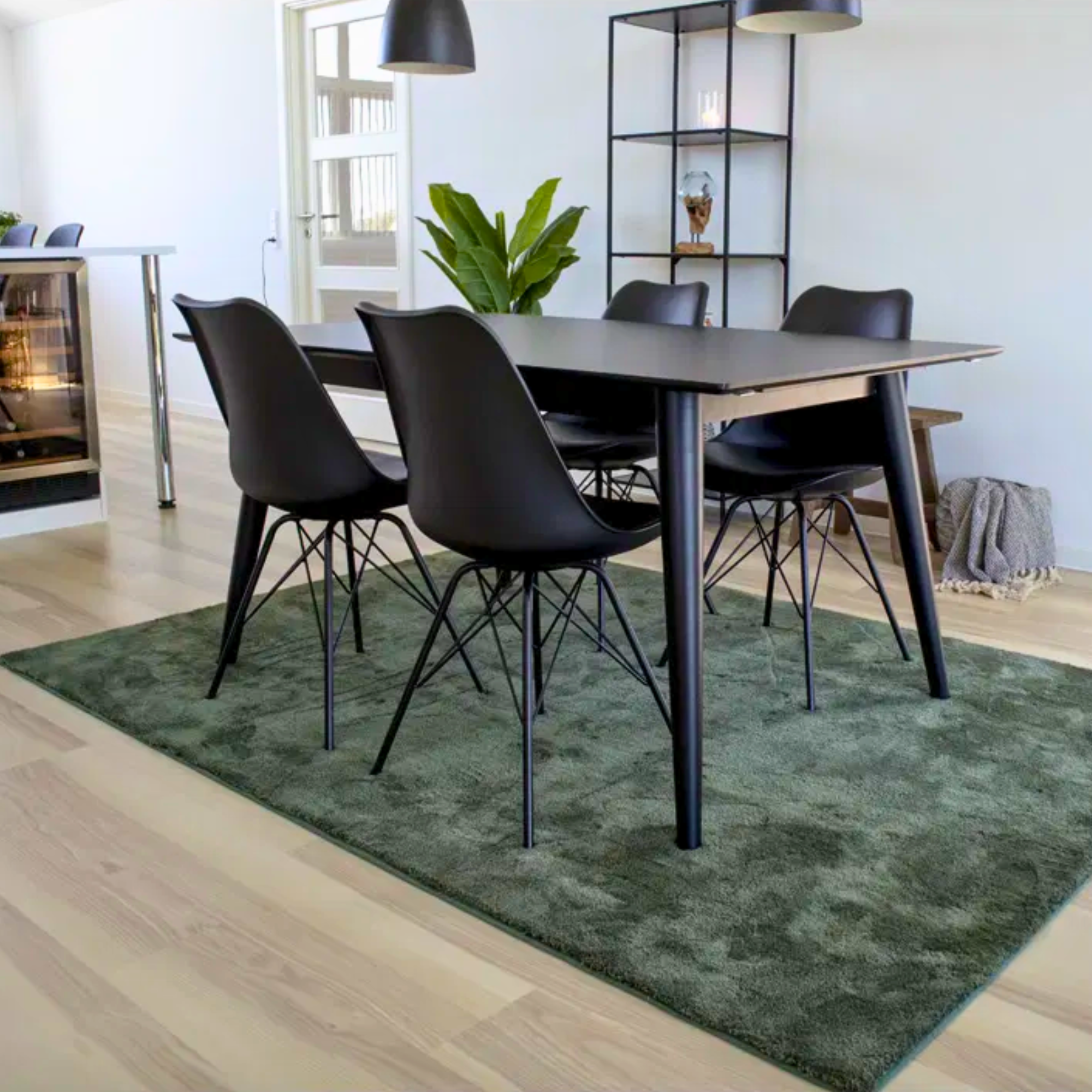 Set van twee House Nordic Oslo eetkamerstoelen in zwart met zwarte poten, geplaatst aan eettafel in Scandinavisch interieur.