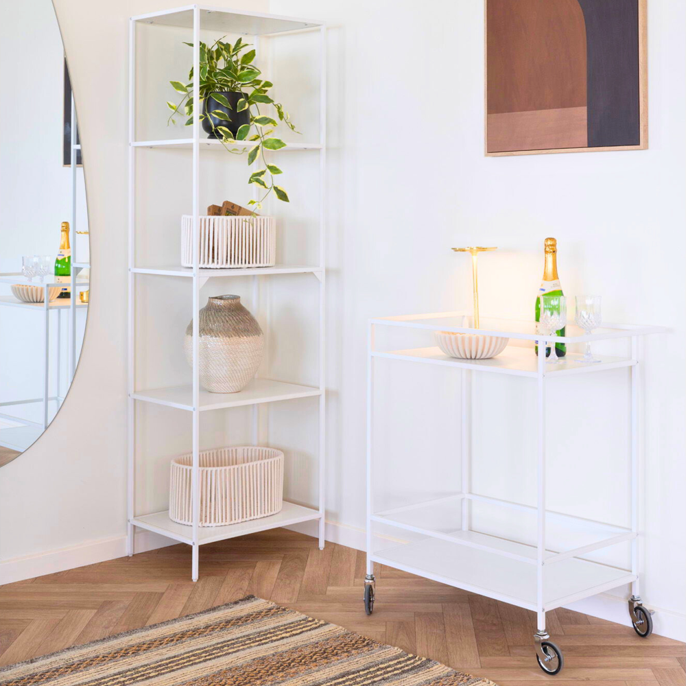 House Nordic Vita serveerwagen in wit met champagnefles en lamp in Scandinavisch interieur met houten vloer en wandkast.