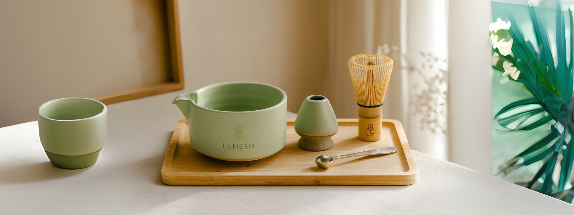 Lunero matcha set op bamboe tray met whisk en kopje in zonnig, minimalistisch interieur.