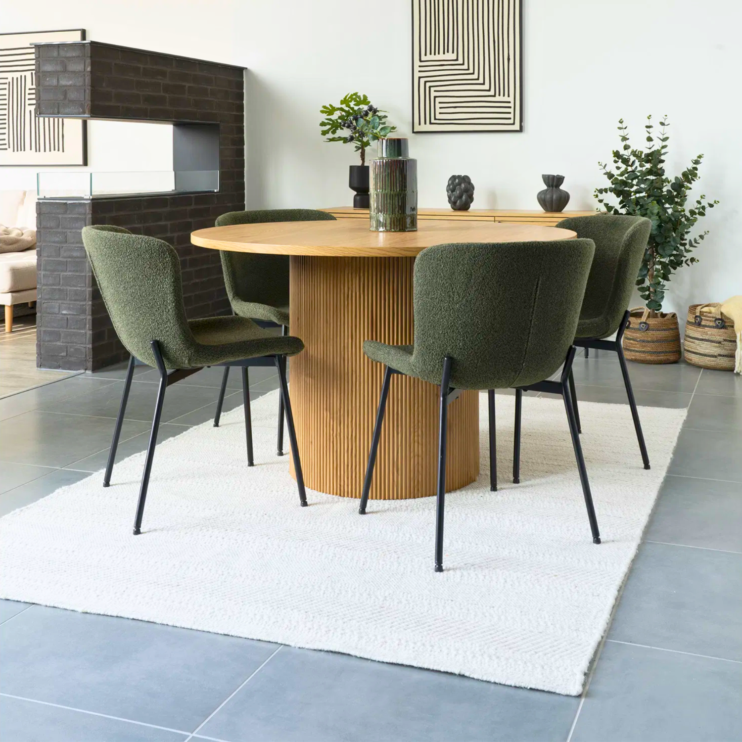 Set Maceda eetkamerstoelen in groene bouclé met zwarte metalen poten van House Nordic, gestyled rond een ronde eettafel in Scandinavisch interieur.