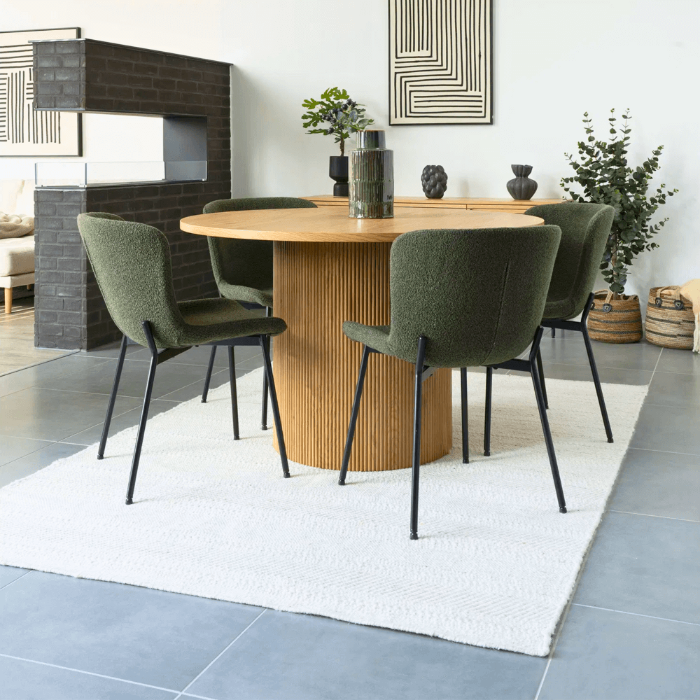 Set Maceda eetkamerstoelen in groene bouclé met zwarte metalen poten van House Nordic, gestyled rond een ronde eettafel in Scandinavisch interieur.