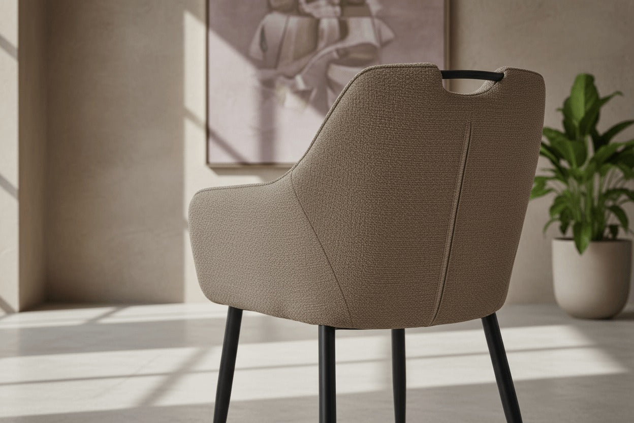 Detail van de RV Design Adele armstoel in taupe, met zichtbare stofstructuur, verfijnde stiknaden en zwart metalen onderstel.