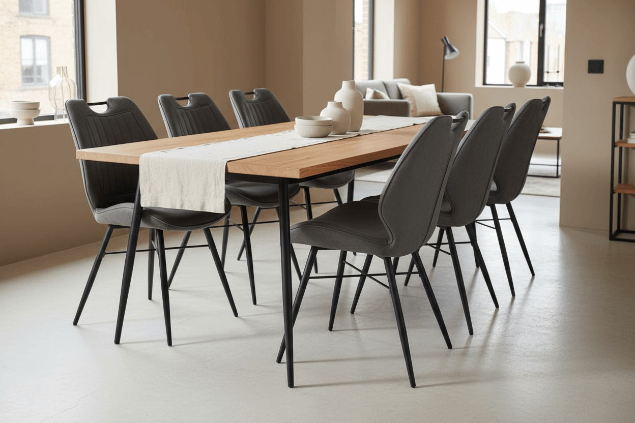 RV Design Quattro eetkamerstoelen in antraciet soft stof rond een moderne houten eettafel met zwart metalen onderstel in een stijlvol interieur.